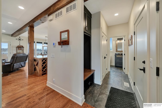 hall with beam ceiling and dark wood-type flooring