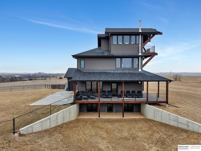 back of house featuring a yard and a rural view