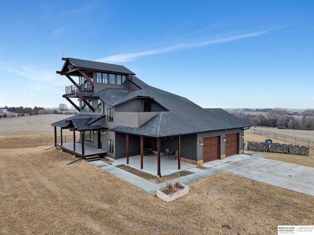 view of front of home featuring a front yard, a rural view, and a patio area