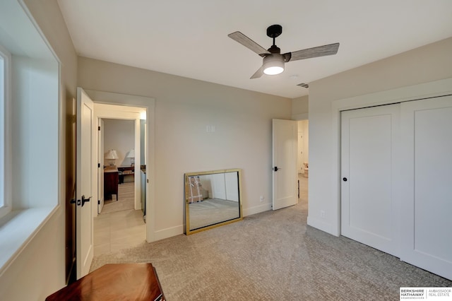 bedroom featuring light carpet, a closet, and ceiling fan