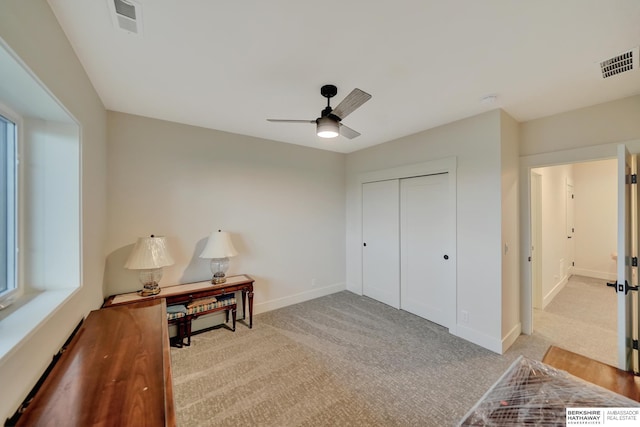 living area featuring light carpet and ceiling fan