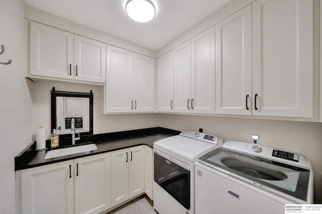 laundry area with cabinets, washer and clothes dryer, and sink