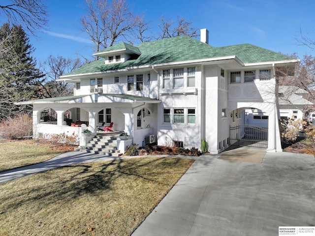 view of front of house with a porch, a garage, and a front lawn