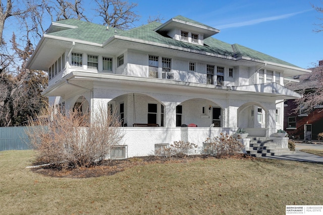 view of front facade featuring a front lawn and a balcony