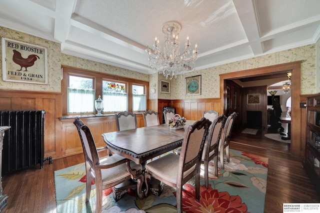 dining room with dark wood-type flooring, radiator heating unit, coffered ceiling, and beamed ceiling