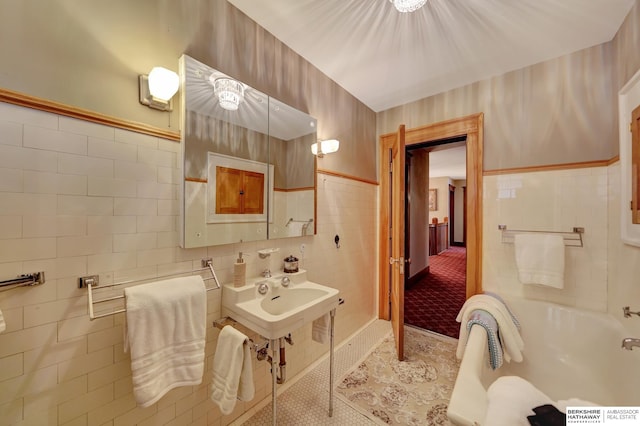 bathroom featuring tile walls, tile patterned floors, and a tub to relax in