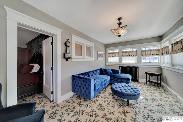 living area featuring radiator heating unit and light carpet