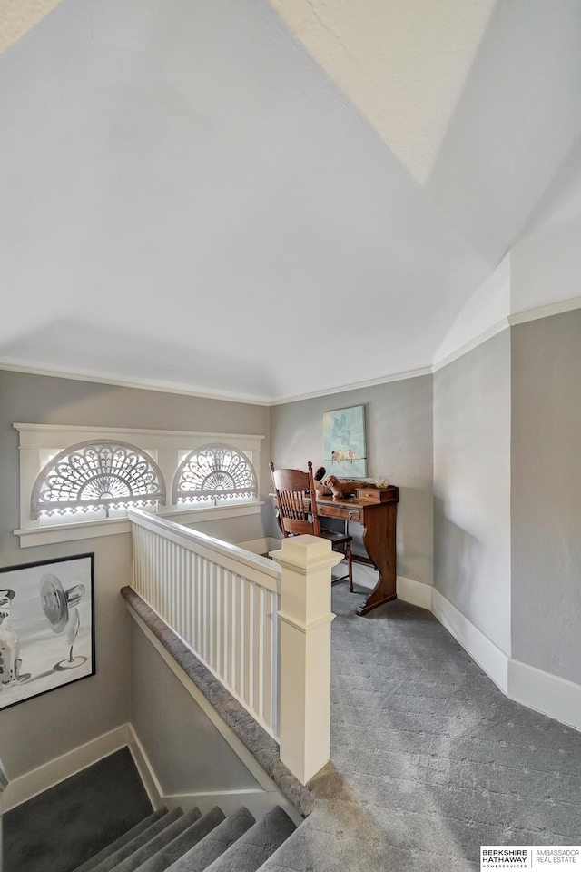 interior space featuring lofted ceiling, ornamental molding, and carpet