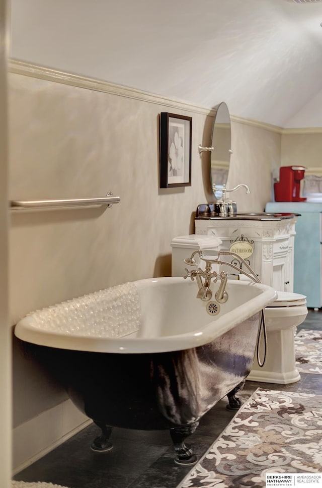 bathroom with lofted ceiling, sink, a bath, and toilet