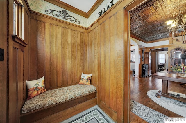 mudroom featuring crown molding, wood-type flooring, and a chandelier