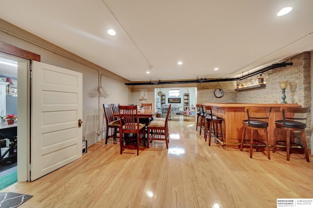 dining area with bar and light hardwood / wood-style floors