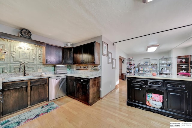 kitchen with stainless steel dishwasher, dark brown cabinetry, light hardwood / wood-style floors, and sink