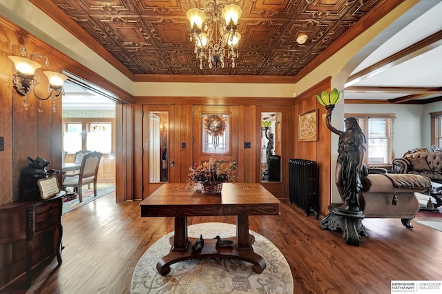 interior space with ornamental molding, hardwood / wood-style floors, and a notable chandelier