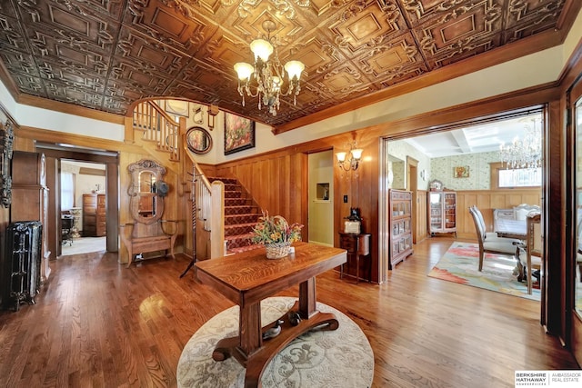 interior space with crown molding, wood-type flooring, and a notable chandelier