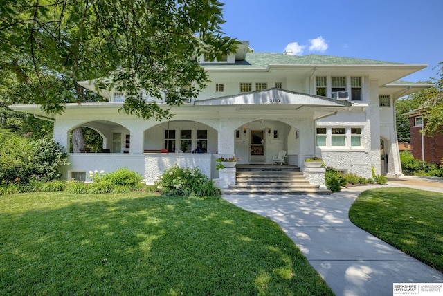 view of front facade with cooling unit, a front lawn, and a porch