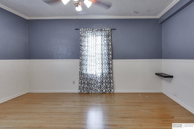 spare room with crown molding, light wood-type flooring, and ceiling fan