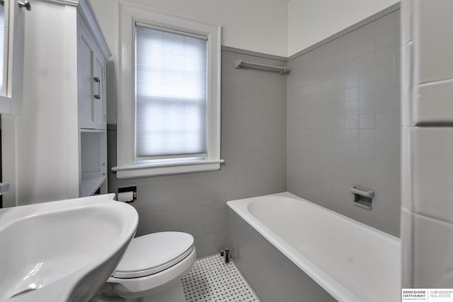 bathroom with sink, a bath, and toilet