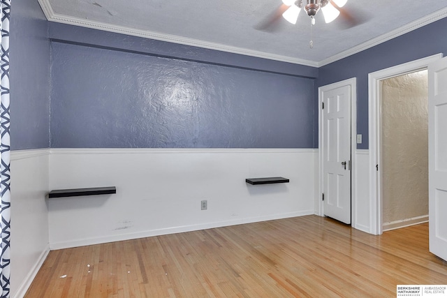 empty room featuring crown molding, ceiling fan, and hardwood / wood-style floors