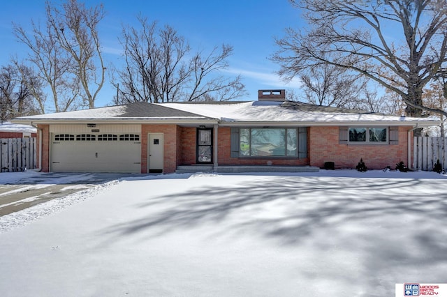 view of front of home featuring an attached garage, fence, and brick siding