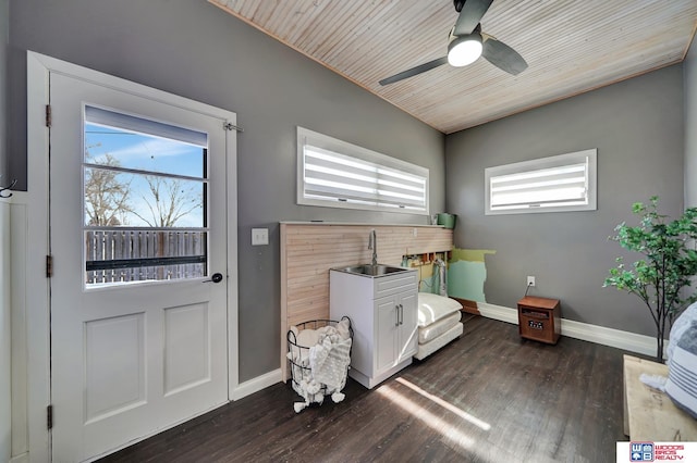 interior space featuring ceiling fan, baseboards, dark wood-type flooring, and a sink