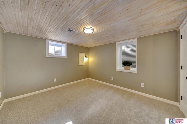 carpeted spare room with wood ceiling, visible vents, and baseboards