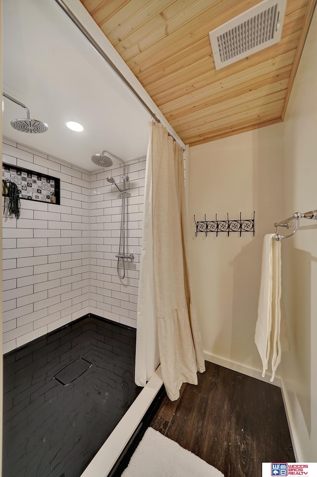 bathroom featuring baseboards, visible vents, wood ceiling, wood finished floors, and a shower stall