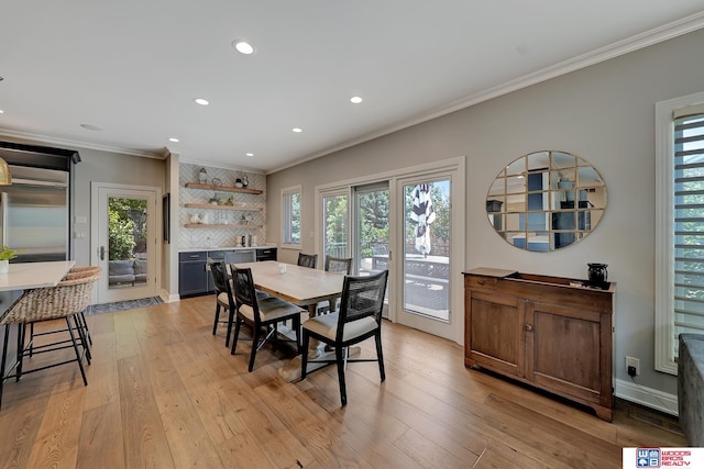 dining area featuring crown molding and light hardwood / wood-style flooring