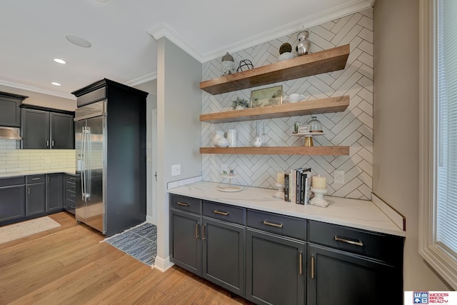 bar with ornamental molding, light stone countertops, backsplash, and light wood-type flooring