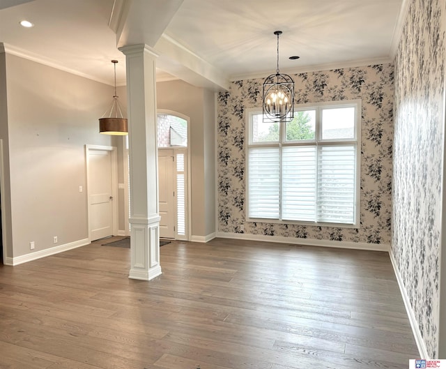 unfurnished room with ornamental molding, dark wood-type flooring, decorative columns, and a chandelier