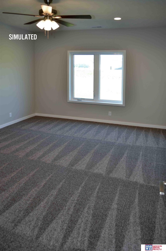 empty room with ceiling fan and dark carpet