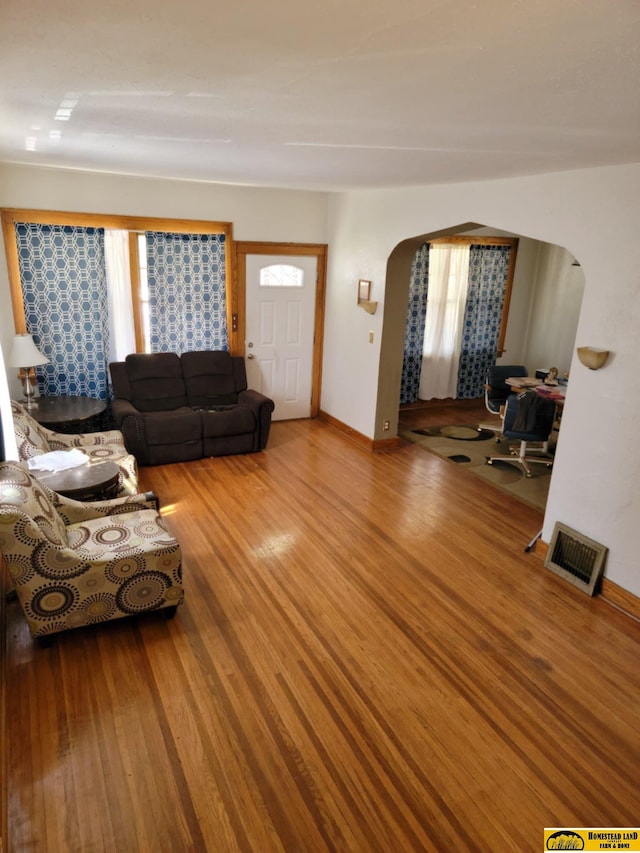 unfurnished living room featuring hardwood / wood-style flooring and plenty of natural light