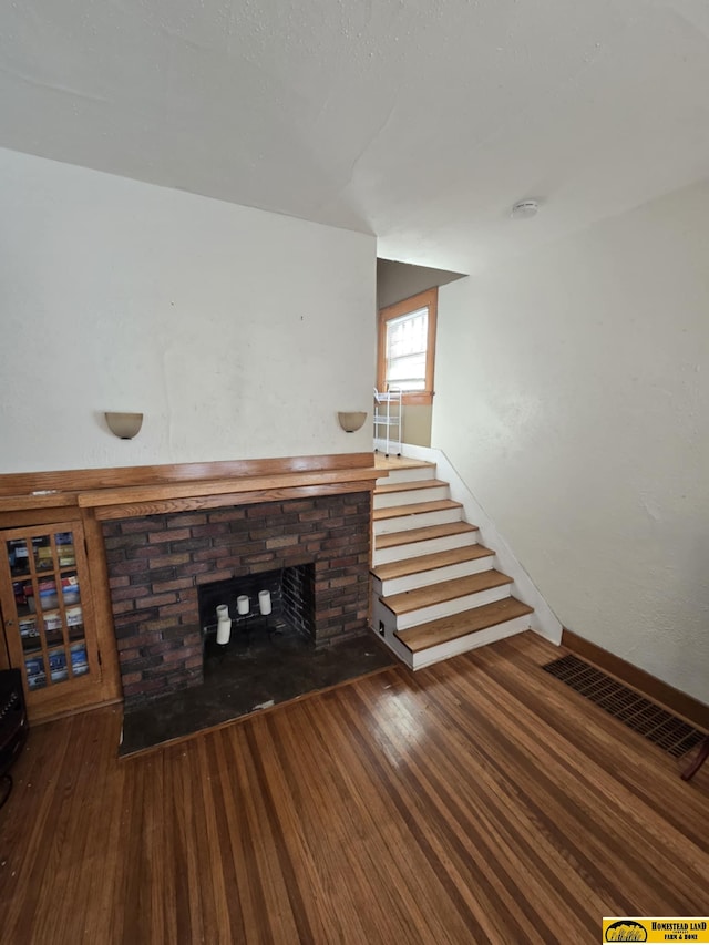 unfurnished living room with a fireplace and dark hardwood / wood-style flooring