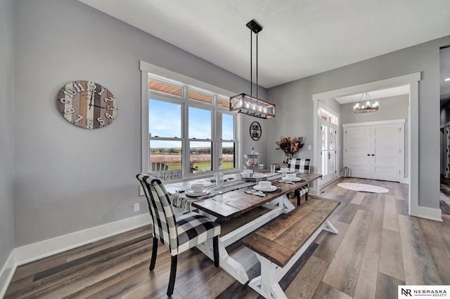 dining room featuring an inviting chandelier and dark wood-type flooring