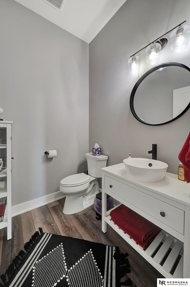 bathroom featuring vanity, hardwood / wood-style flooring, and toilet