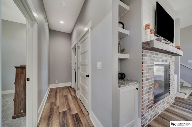 hallway featuring built in shelves and wood-type flooring