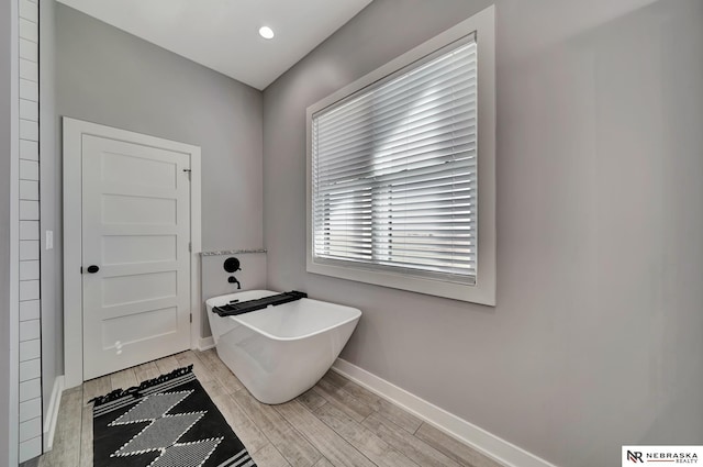 bathroom with a bathing tub and wood-type flooring