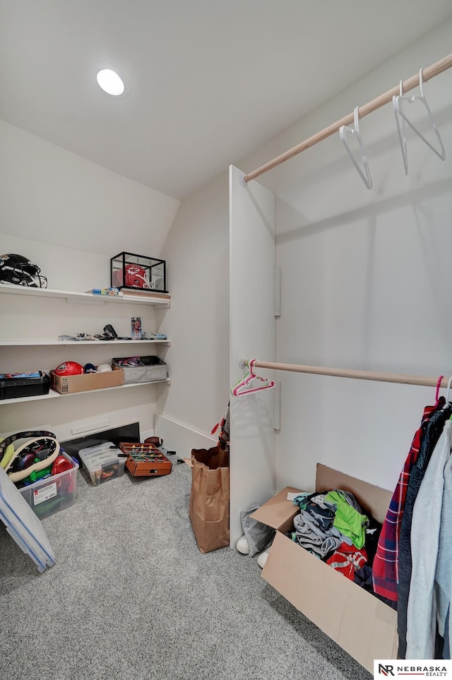 walk in closet with vaulted ceiling and carpet flooring