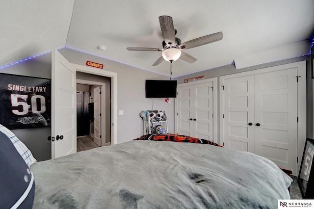 bedroom with lofted ceiling, two closets, and ceiling fan