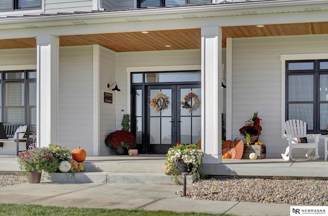 property entrance featuring french doors and a porch