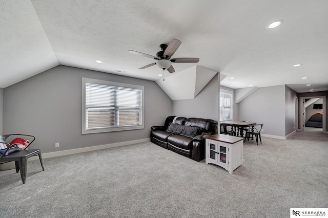 carpeted living room featuring ceiling fan and vaulted ceiling