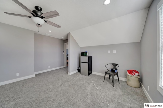 additional living space featuring lofted ceiling, light carpet, and ceiling fan