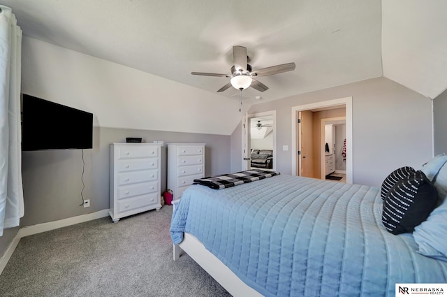 bedroom featuring vaulted ceiling, light colored carpet, ceiling fan, and ensuite bath