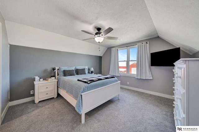 carpeted bedroom with vaulted ceiling, a textured ceiling, and ceiling fan