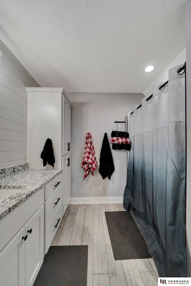 bathroom featuring vanity, hardwood / wood-style floors, a textured ceiling, and a shower with shower curtain