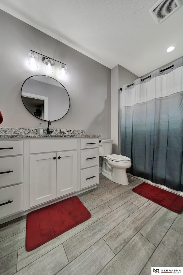 bathroom featuring vanity, a shower with shower curtain, and toilet