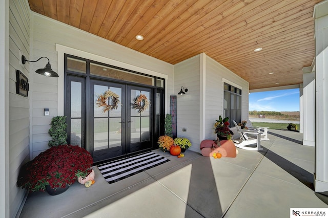 doorway to property with covered porch and french doors