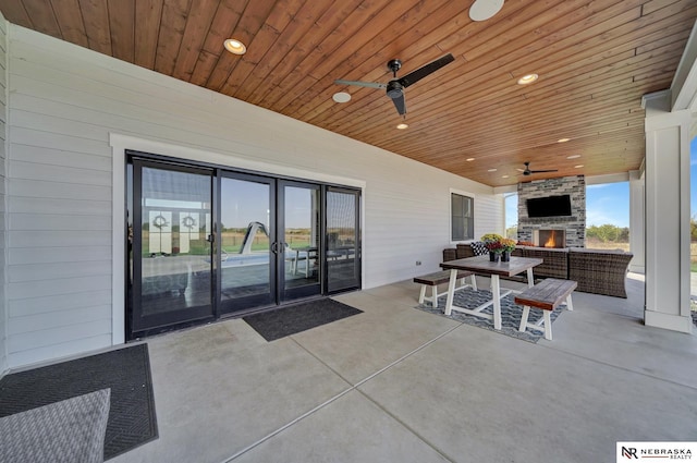 view of patio with ceiling fan and an outdoor living space with a fireplace