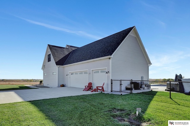 view of side of home featuring a garage and a lawn