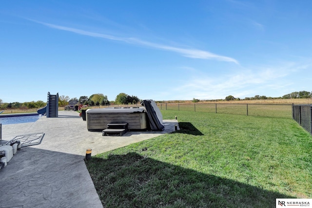 view of yard with a hot tub, a patio area, and a rural view