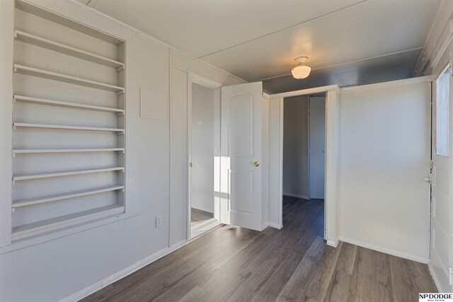 unfurnished bedroom featuring dark wood-type flooring and a closet